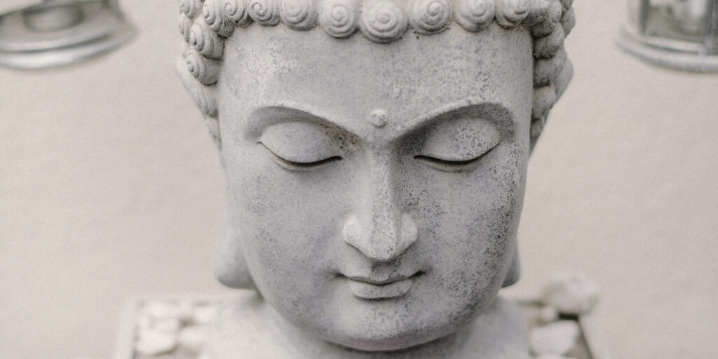 psychologist-01 Nahaufnahme eines steinernen Buddha-Kopfes mit geschlossenen Augen